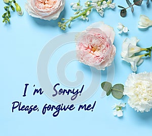 Apology card design with flowers and text I\'m Sorry! Please, Forgive Me! on light blue background, flat lay