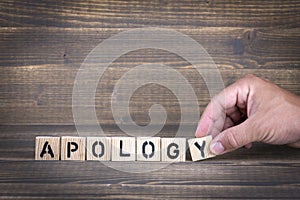 Apology. Wooden letters on the office desk