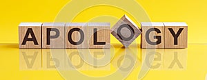 APOLOGY - word from wooden blocks with letters, sorry concept, yellow background