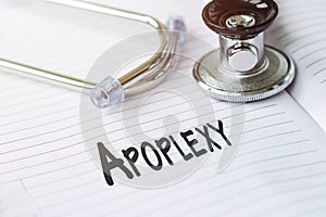 APOPLEXY. Text on a medical card next to a pen stethoscope photo