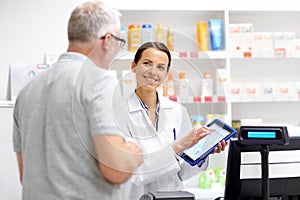Apothecary and customer with tablet pc at pharmacy