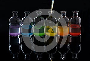 Apothecary, laboratory bottles with colored liquid and pipette photo