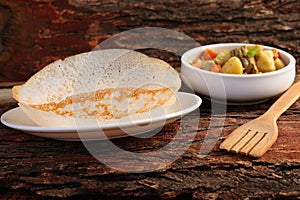 Appam served with hearty mutton stew