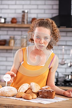 Appealing curly-haired girl having allergy on gluten contained in bread