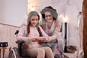 Appealing woman and disabled girl surfing Internet