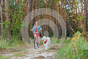 Appealing woman riding bike in the morning with her husky