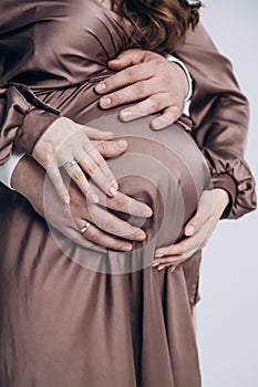 The appearance of the firstborn. First birth. Pregnancy. Hands rest on the pregnant belly