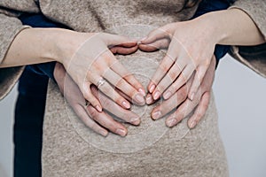 The appearance of the firstborn. First birth. Pregnancy. Hands rest on the pregnant belly photo