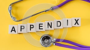 APPENDIX word made with wooden building blocks with stethoscope on yellow table. Medical concept