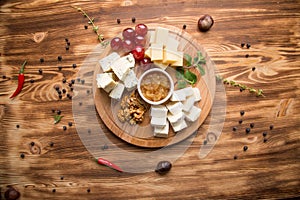 appetizer of assorted cheeses for wine. Cheese platter assorted: dor blue  cheddar  goat cheese  feta cheese. Nuts and honey for