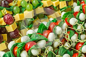 Appetizer canape cheese with white and red grapes on bamboo skewers