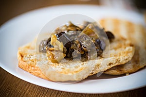 Appetizer of cooked eggplant with vegetables on bread