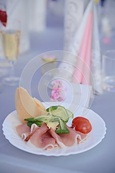 Appetizer a ham and a beautiful table setting at a wedding