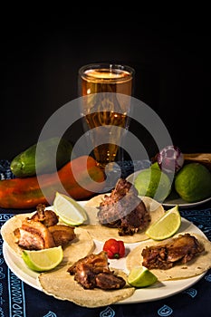 Appetizer made with tortilla and delicious fried pork rinds on a plate decorated with a tridicional tablecloth with lemons and