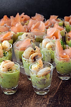 Appetizer on the party buffet with prawn shrimps and salmon on a