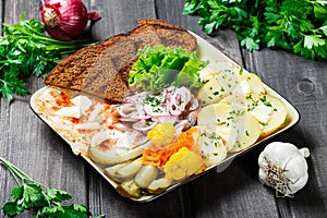 Appetizer platter, baked potato, delicious sliced pork fat with spices, sliced smoked fish with onions