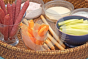 Appetizer platter consisting of sausage, breadsticks and sauces