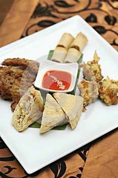 Appetizer platter; prawn fritters, spring roll, stuffed tofu and fried chicken wings