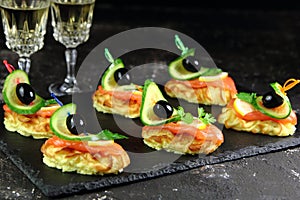 Appetizer of potatoes and salmon with cucumber and olives