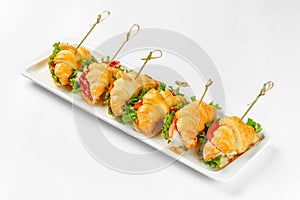 Appetizer sandwiches on a white plate on a white background. Catering service
