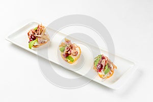 Appetizer sandwiches on a white plate on a white background. Catering service