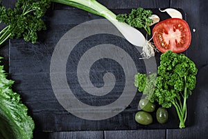 Appetizer set on wooden board. With olives,parsley,garlic. Top view. Dark background.