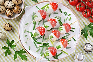 Appetizer on skewers from quail eggs, cherry tomatoes with mayonnaise.