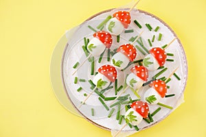 Appetizer on skewers from quail eggs, cherry tomatoes with mayonnaise.
