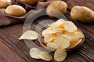 Appetizer and Snack food. Crispy potato chips on plate with fresh potatoes