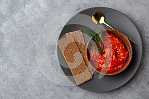 Appetizer of vegetables ajvar, lutenitsa, pingjur, harissa with bread on a plate