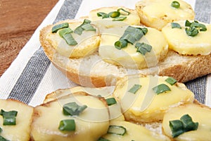 Appetizer of wheat bread, potatoes, cheese and green onions