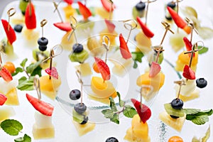 Appetizers, gourmet food - canape with cheese and strawberries, blue-berries catering service. selective focus, top view