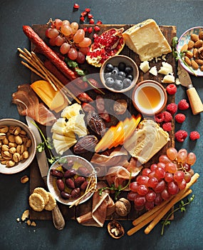 Appetizers platter with various of cheese, curred meat, sausage, olives, nuts and fruits