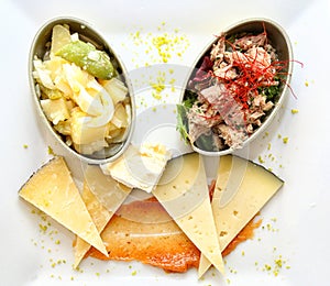 Appetizers in sardine cans and cheese wedges on carrot sauce photo