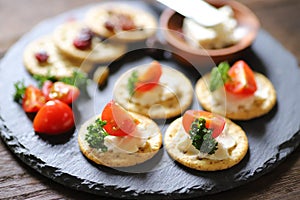 Appetizers and snacks, crackers, dried fruit, tomatoes, parsley, and cream cheese