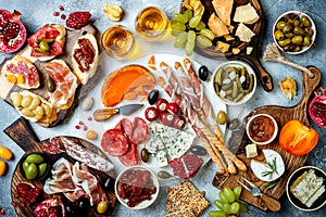 Appetizers table with antipasti snacks and wine in glasses. Bruschetta or authentic traditional spanish tapas set
