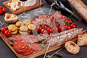 Appetizers table with differents antipasti, cheese, charcuterie, snacks and wine. Mini burgers, sausage, ham, tapas, olives, chees