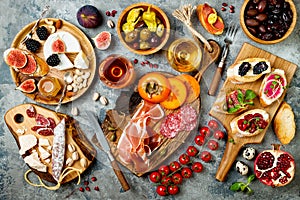 Appetizers table with italian antipasti snacks and wine in glasses. Brushetta or authentic traditional spanish tapas set