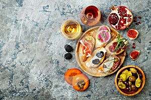 Appetizers table with italian antipasti snacks and wine in glasses. Brushetta or authentic traditional spanish tapas set