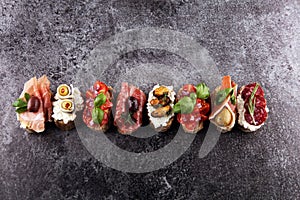 Appetizers table with italian antipasti snacks and wine in glasses. Brushetta or authentic traditional spanish tapas set, cheese