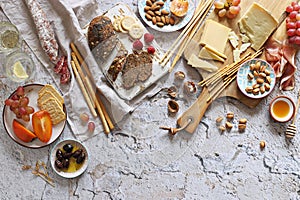 Appetizers table with various of cheese, curred meat, sausage, olives, nuts and fruits.