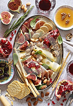 Appetizers table with various of cheese, curred meat, sausage, olives, nuts and fruits.