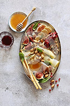 Appetizers table with various of cheese, curred meat, sausage, olives, nuts and fruits.