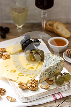 Appetizers of various types of cheese, grapes, nuts and honey, served with white and red wine. Rustic style