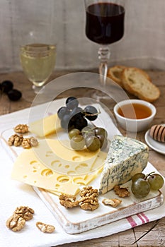 Appetizers of various types of cheese, grapes, nuts and honey, served with white and red wine. Rustic style