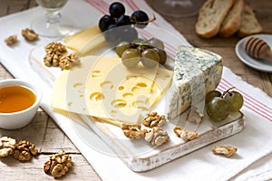 Appetizers of various types of cheese, grapes, nuts and honey, served with white and red wine. Rustic style