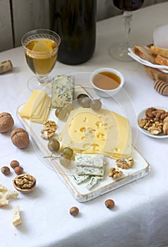 Appetizers of various types of cheese, grapes, nuts and honey, served with white and red wine. Rustic style