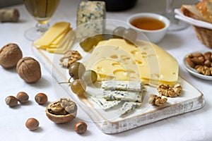 Appetizers of various types of cheese, grapes, nuts and honey, served with white and red wine. Rustic style.
