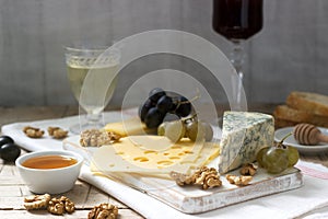 Appetizers of various types of cheese, grapes, nuts and honey, served with white and red wine. Rustic style