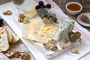 Appetizers of various types of cheese, grapes, nuts and honey, served with white and red wine. Rustic style